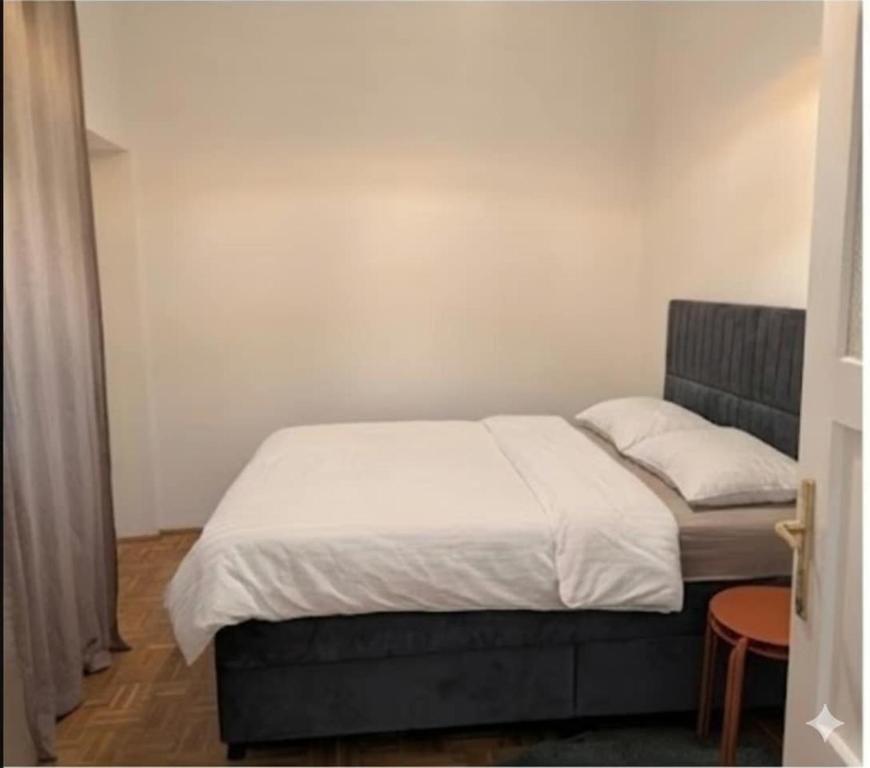 um quarto com uma cama com lençóis e travesseiros brancos em Stylish Old Town Apartment with Infrared Sauna em Linz