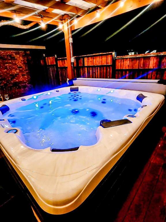 a large hot tub with blue water in a room at Hillside Paradise in Cedar Hill