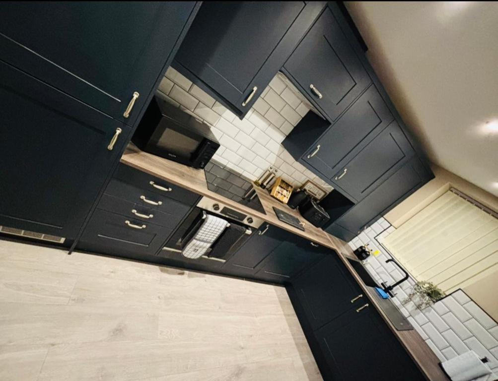 una vista aérea de una cocina con armarios negros en Tarn House Apartment South Yorksire, en Barnsley
