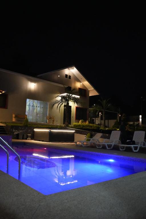 a swimming pool at night with chairs and a house at Quinta Nallig in Gualaceo