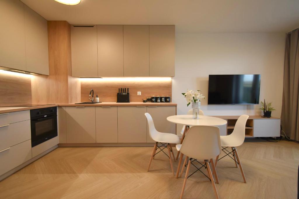 Szpitalna Residence & Garage في سووالكي: مطبخ مع طاولة بيضاء وكراسي بيضاء