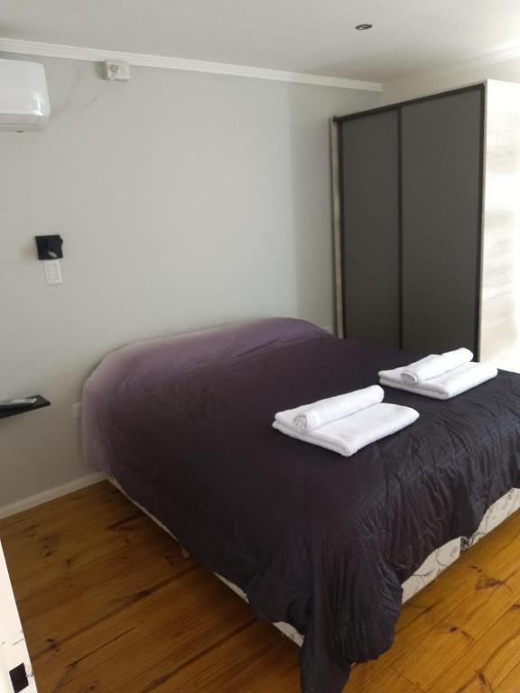 una camera da letto con un letto con due asciugamani sopra di JAS departamento a General Acha