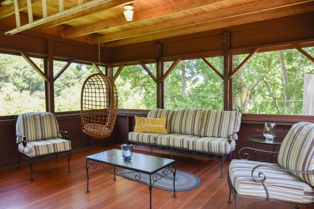 a screened in porch with two couches and a table at Private Downtown Wellfleet Location in Wellfleet