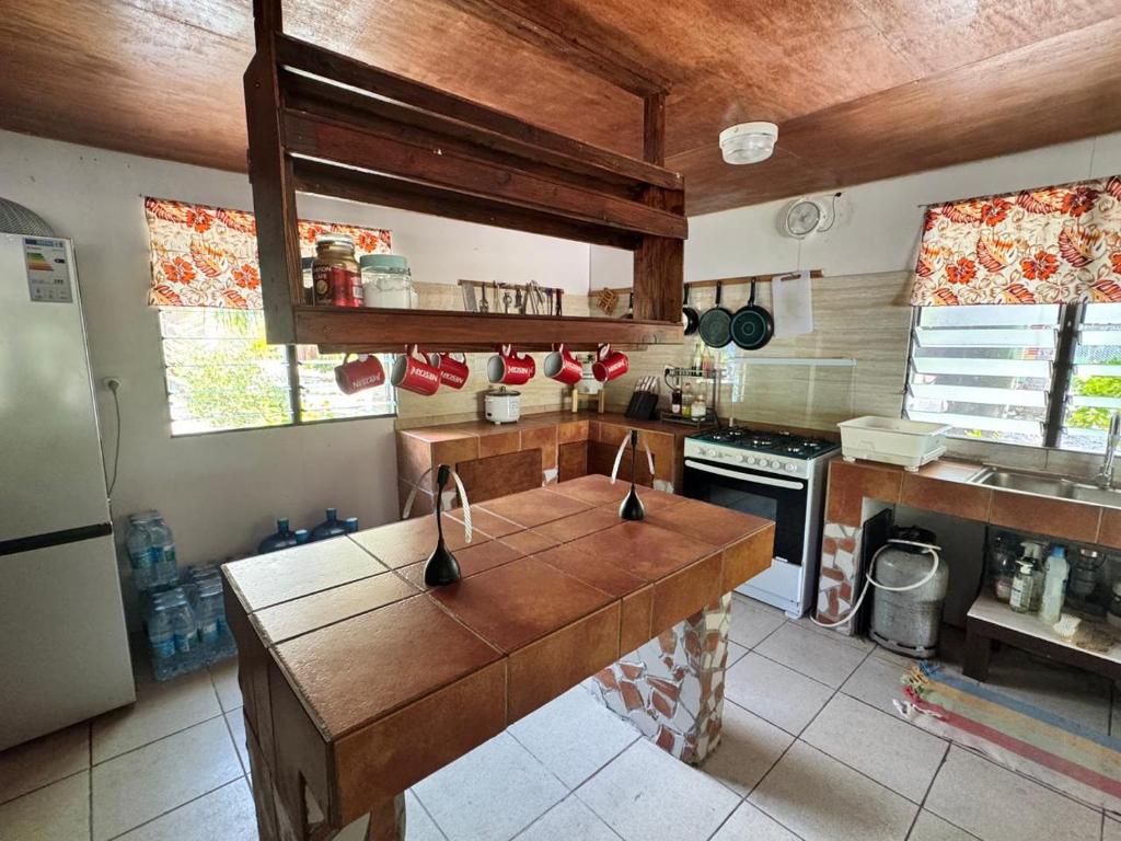 a kitchen with a wooden island in the middle at Motu Tahuhu Lodge in Rangiroa