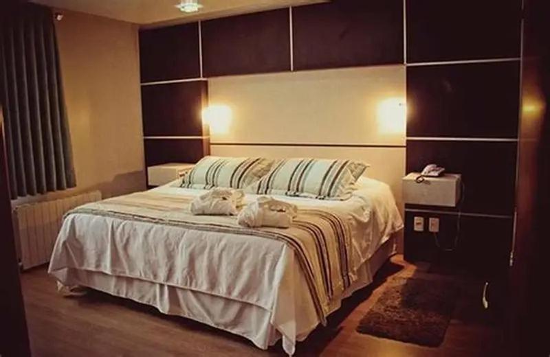 une chambre avec un grand lit avec deux serviettes dessus dans l'établissement La Posada Huamanguina, à San Antonio