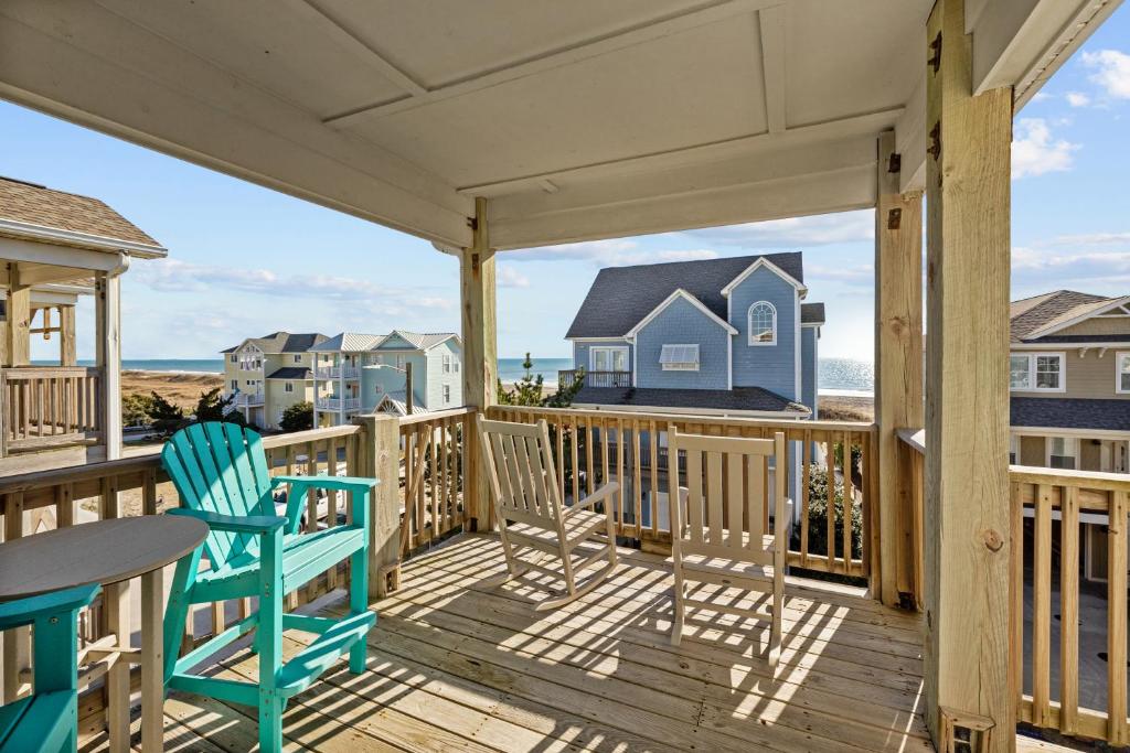 a porch with chairs and a table and a view of the ocean at Penthouse in Atlantic Beach