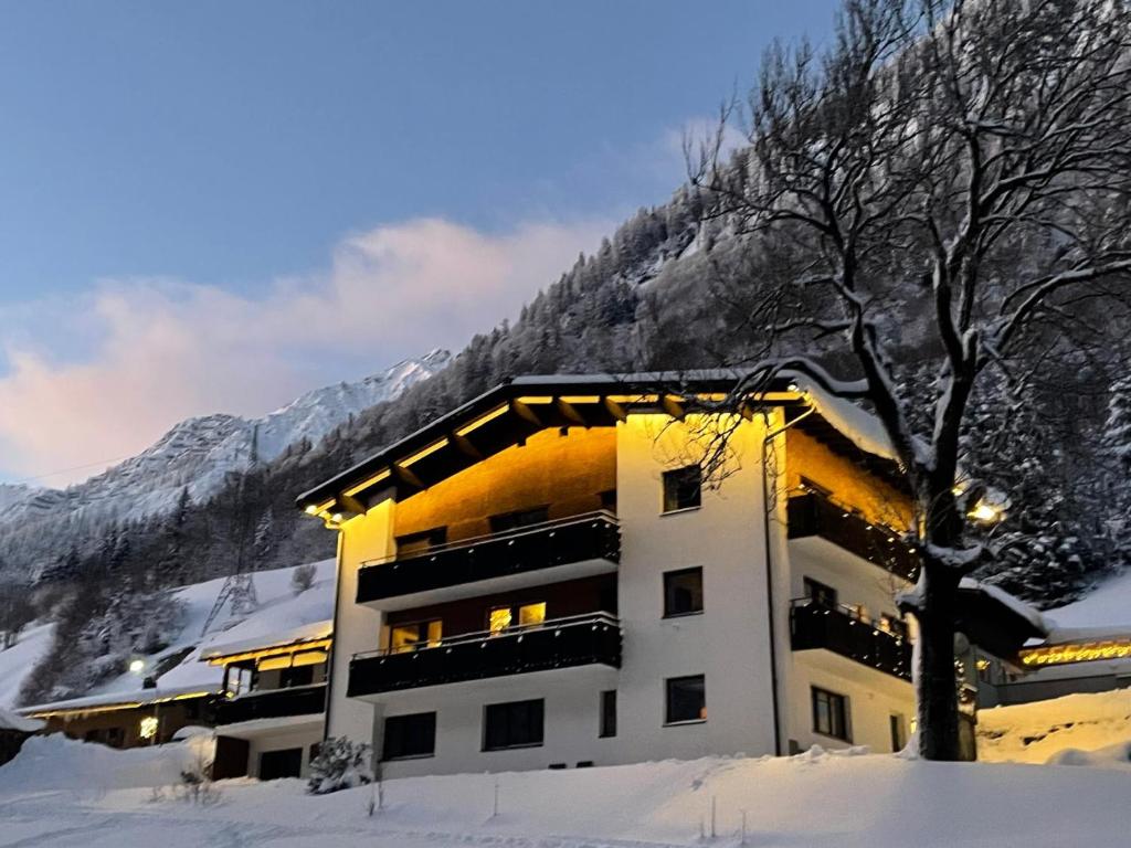 a building in the snow in front of a mountain at Alpin Haus Klösterle in Wilden