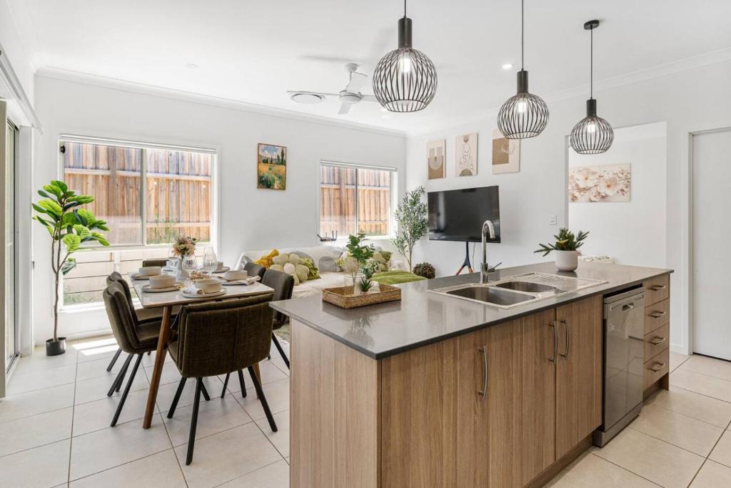 a kitchen and living room with a table and a sink at Comfy Home in Deebing Heights in Loamside