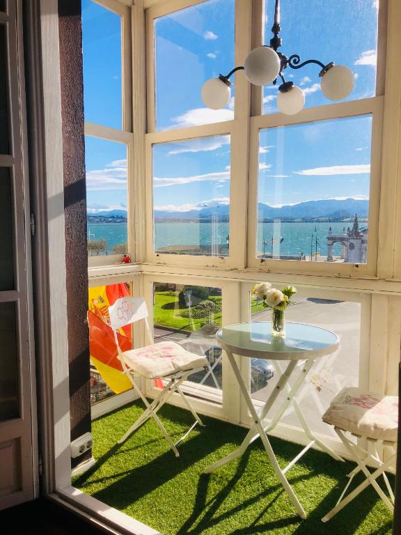 a table and chairs in a room with a large window at Hostel Santander in Santander