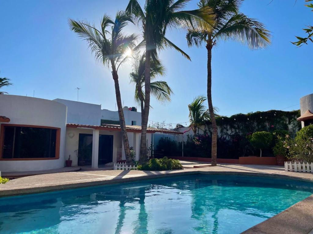 a swimming pool in front of a house with palm trees at Garden and Pool Casita in La Paz