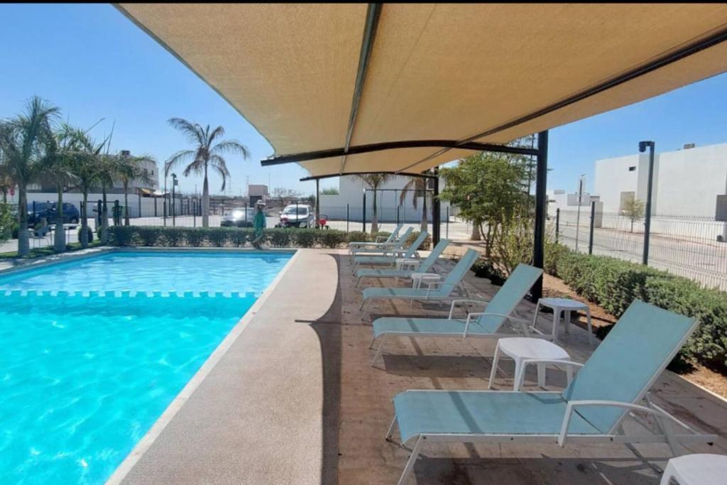 Los BledalesWater House的带躺椅和遮阳伞的游泳池