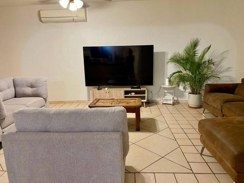 un soggiorno con un divano e una TV di Casa Flor y Agua a La Ardilla