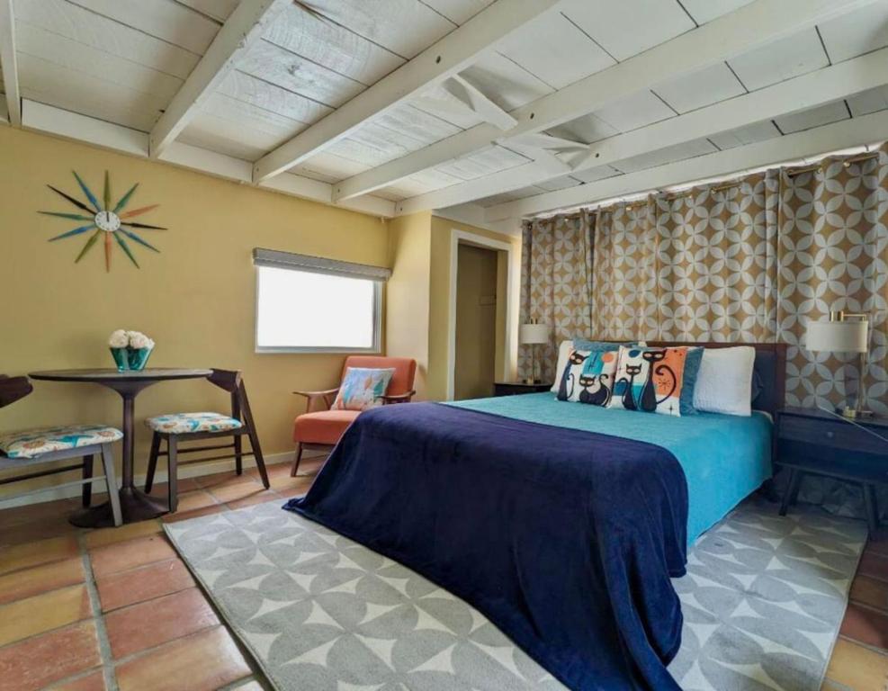 a bedroom with a blue bed and a table and chair at Mid-century marvelous 1 bed, pets welcome in Las Cruces