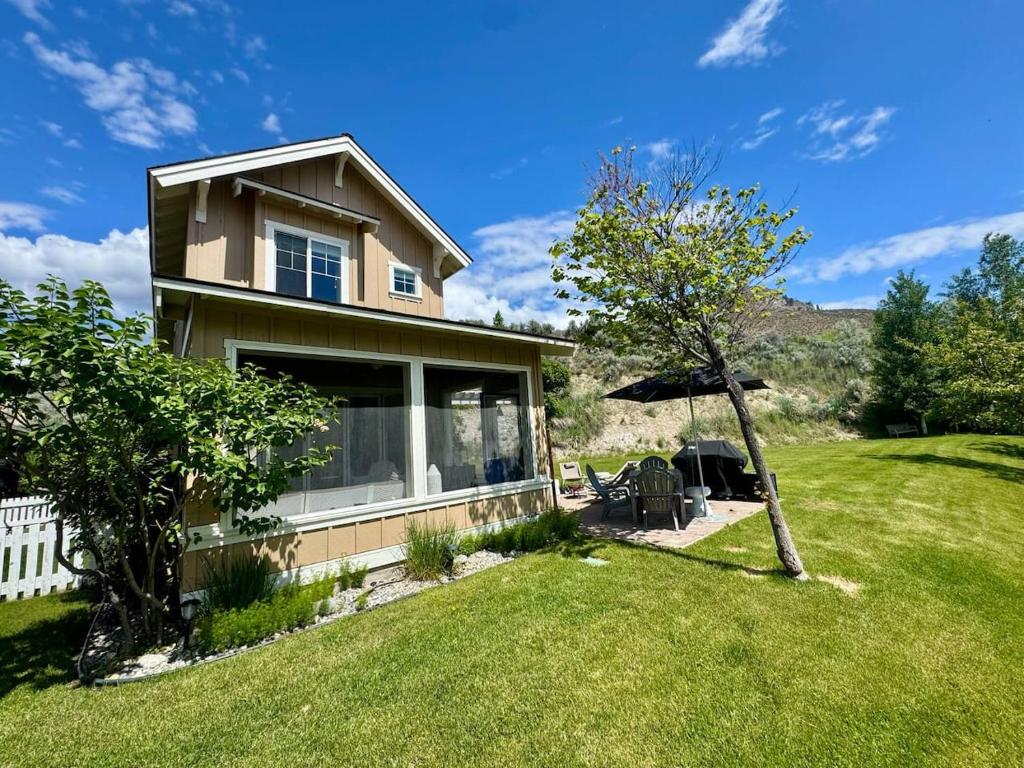 a house with a green yard with a tree at Honeysuckle Beach Oasis at Veranda Beach in Oroville