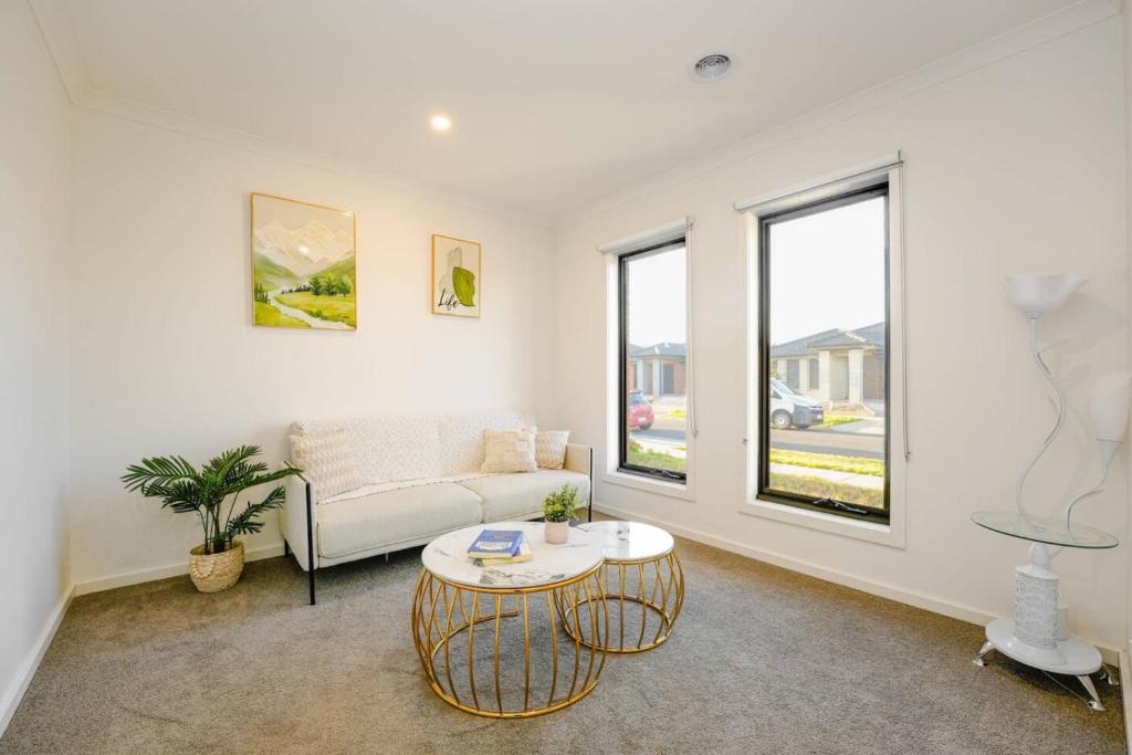 Melton SouthにあるOpen Plan Comfort Sunny Living BBQ in Backyardのソファとテーブルのあるリビングルーム