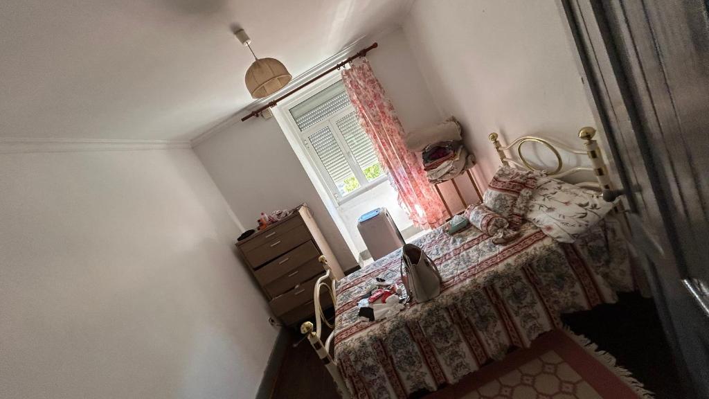 una habitación con una cama y una ventana y un espejo en Maison portugal, en Caria