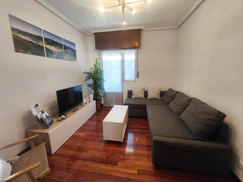 a living room with a couch and a tv at Monzubi Etxi Holiday Home Gernika-Lumo in Guernica y Luno