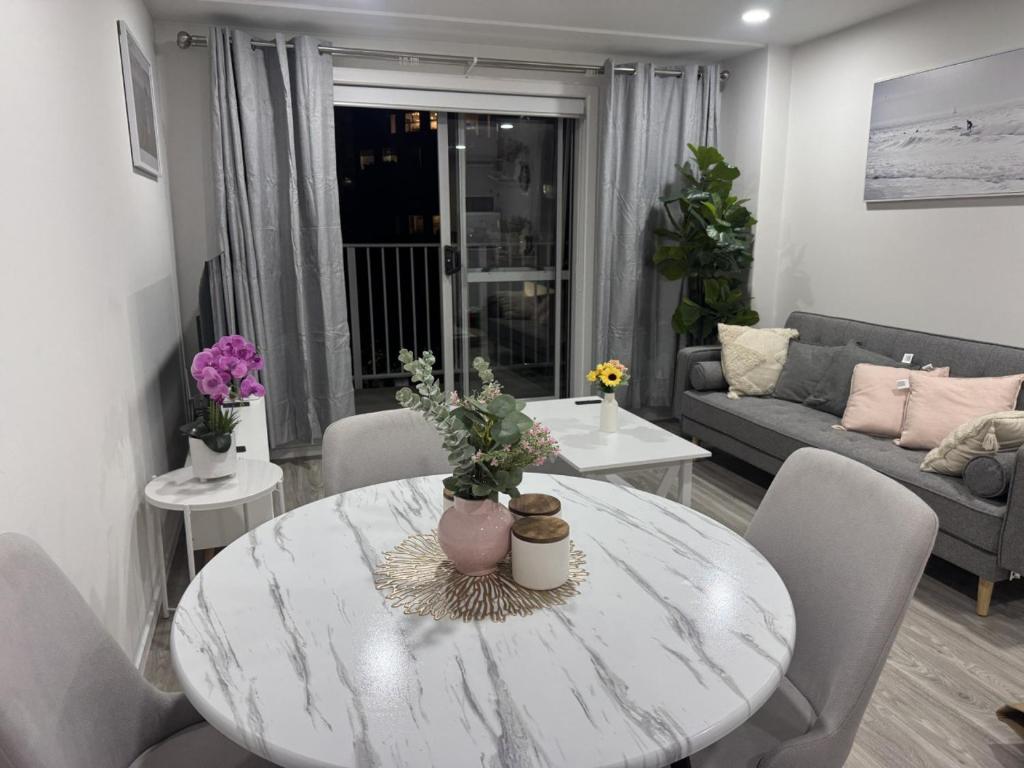 a living room with a white table and chairs at Charming & Cozy Apartment in the Heart of Auckland - 2 bd-2 bth-free carpark in Auckland
