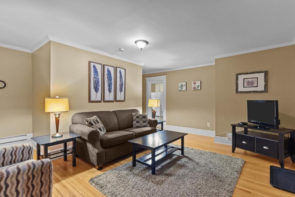 een woonkamer met een bank en een tv bij Midstream Modern 2BR Wi-Fi Parking in St. John's