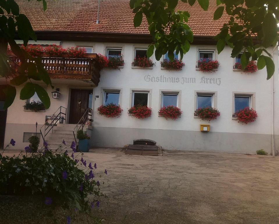Gasthaus zum Kreuz في غرافنهاوسن: مبنى عليه علب ورد