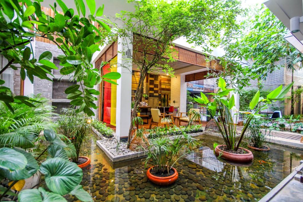 uma casa com um jardim com plantas e um lago em Saravoan Royal Palace em Phnom Penh