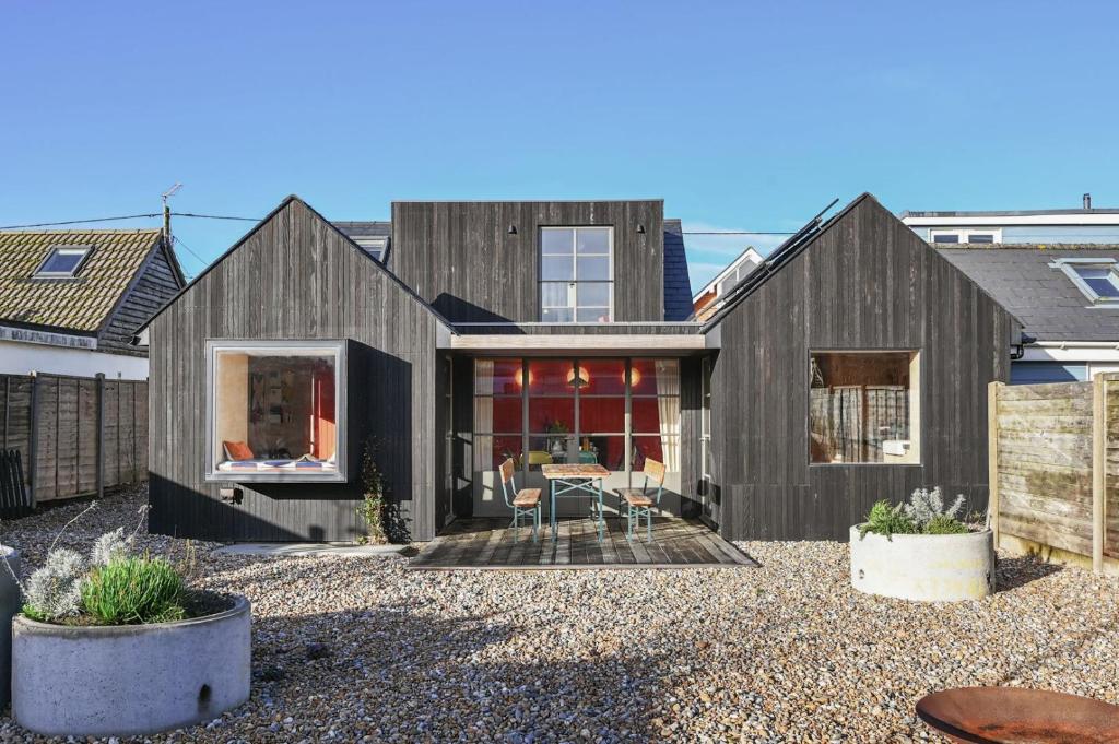 een zwart huis met een zwart dak bij Luna in Camber