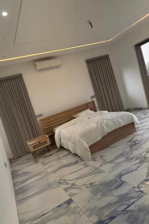 una camera da letto con un letto e un pavimento in marmo di Eliana Castle a Trofwi