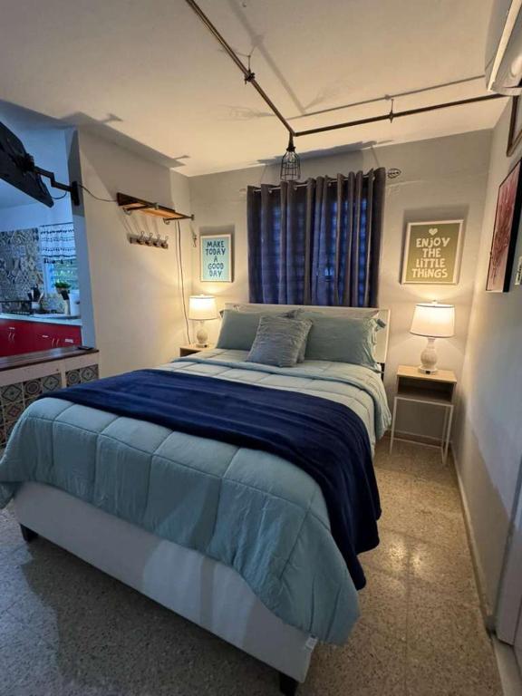 a bedroom with a large bed with blue sheets at The Spot at Rincon in Rincon