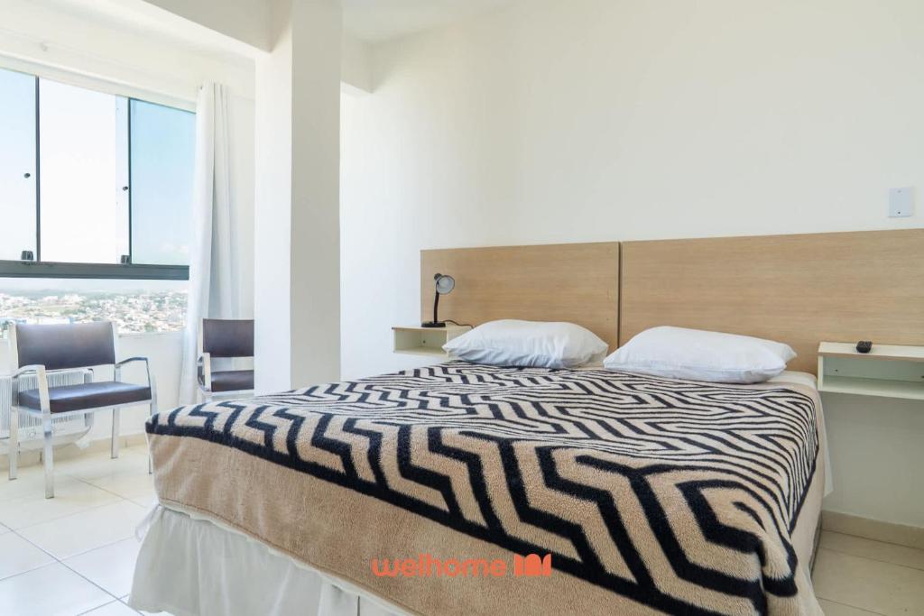 ein Schlafzimmer mit einem Bett mit einer schwarz-weißen Bettdecke in der Unterkunft Apto no Centro de Macae a 550m da Praia do Farol in Imbetiba