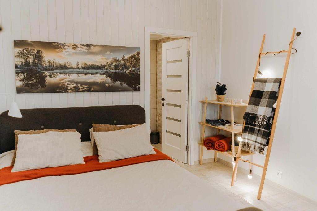 Cottages Family Estate في كامياننيتس - بوديلسكيي: غرفة نوم بها سرير ولوحة على الحائط