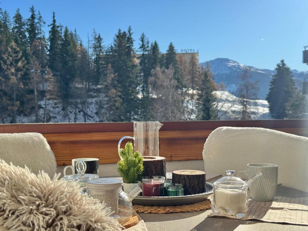 a table with a tray of food on a balcony at Lac & Love - Alpine Escape in Crans-Montana