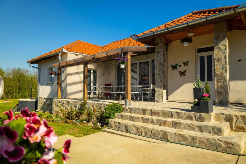 een huis met een veranda en een trap aan de voorkant bij Magic Pine in Cristuru Secuiesc