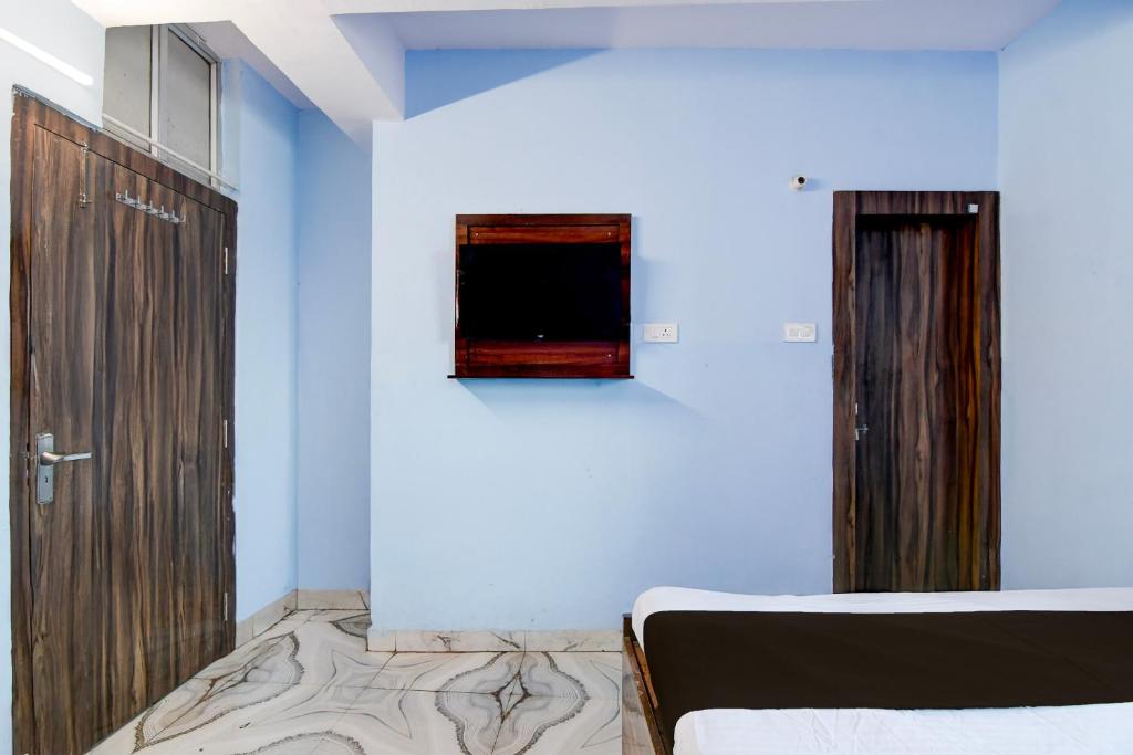 een slaapkamer met een bed en een blauwe muur bij Hotel O Deendayal Crossway Ranchi Formerly Yashoda in Rānchī