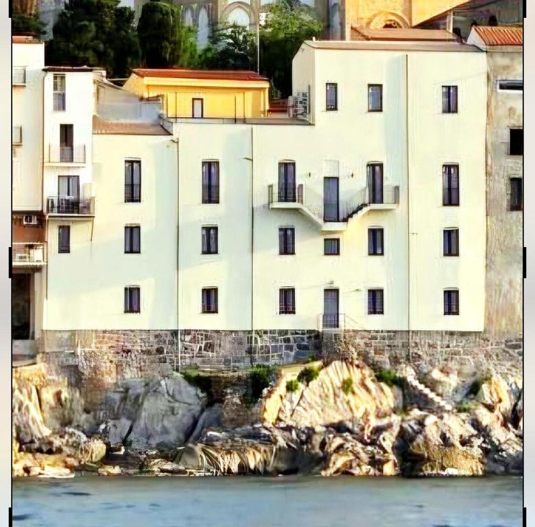 a white building on the side of a mountain at Palazzo Cettina Sul Mare in Cefalù