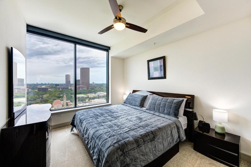 een slaapkamer met een bed en een groot raam bij Hanover River Oaks in Houston