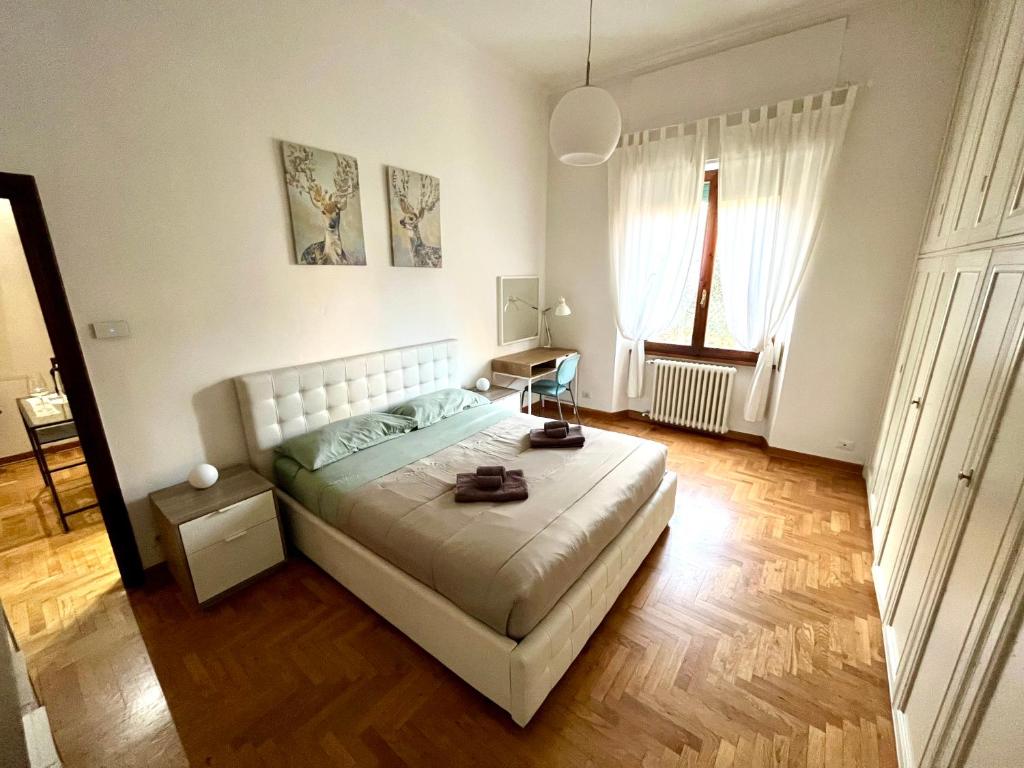 a bedroom with a large white bed and two windows at Florence Lungarno Apartment in Florence