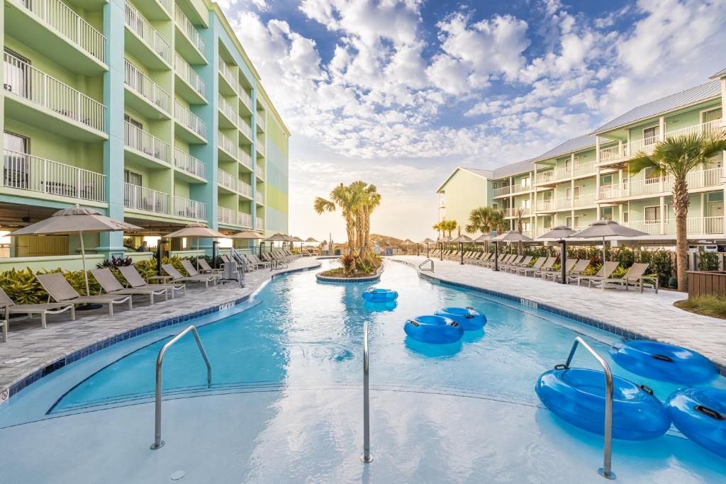 a pool at a resort with inflatables and chairs at Hilton Garden Inn Orange Beach in Orange Beach