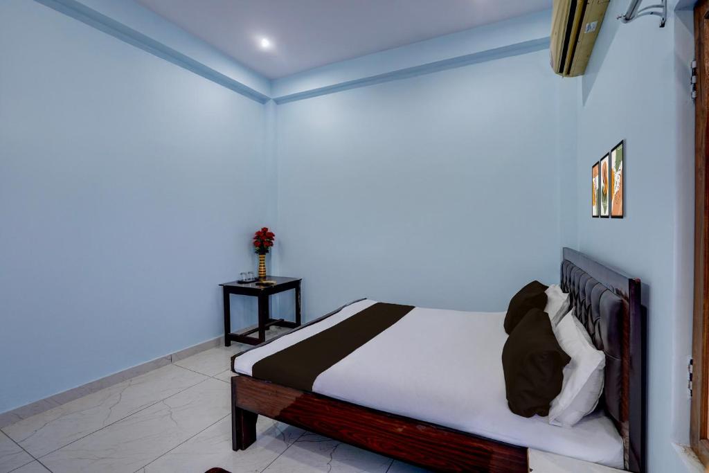 Un dormitorio con una cama en una habitación azul. en Hotel O AK PALACE, en Goshainganj