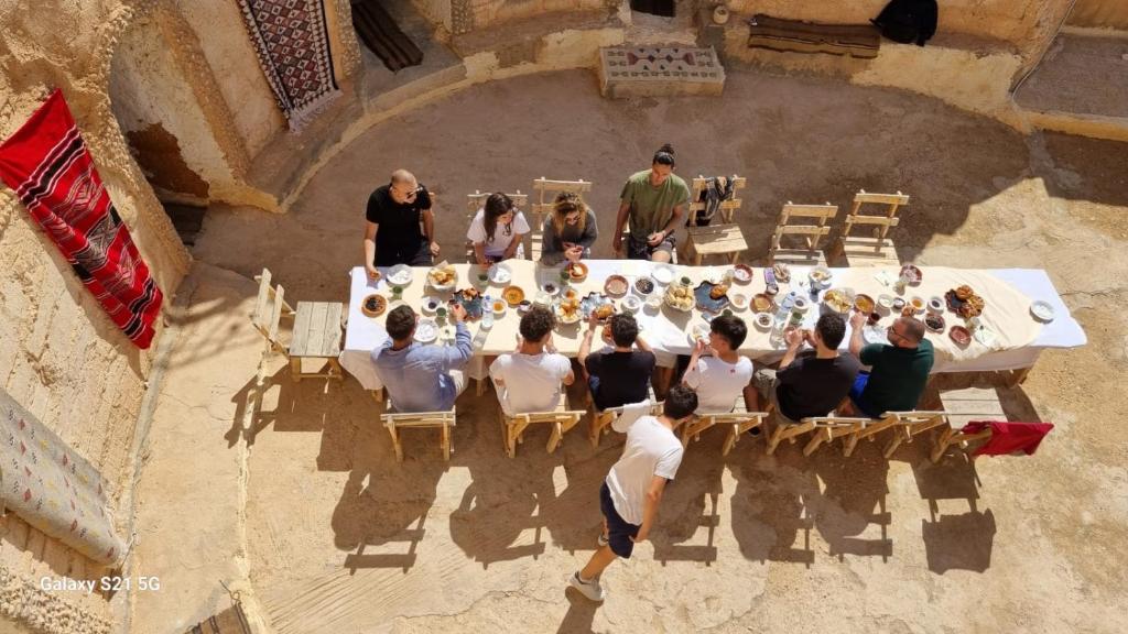 a group of people sitting around a table with a group of people at Dar massouada in Gabès