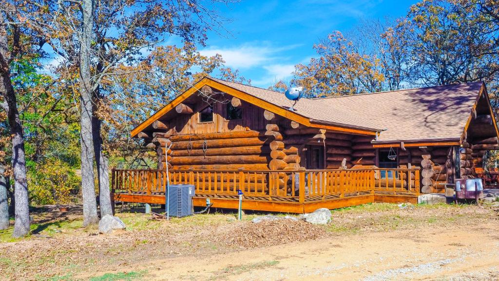 een blokhut in het bos met een hek bij Blue River Inn. Com in Tishomingo