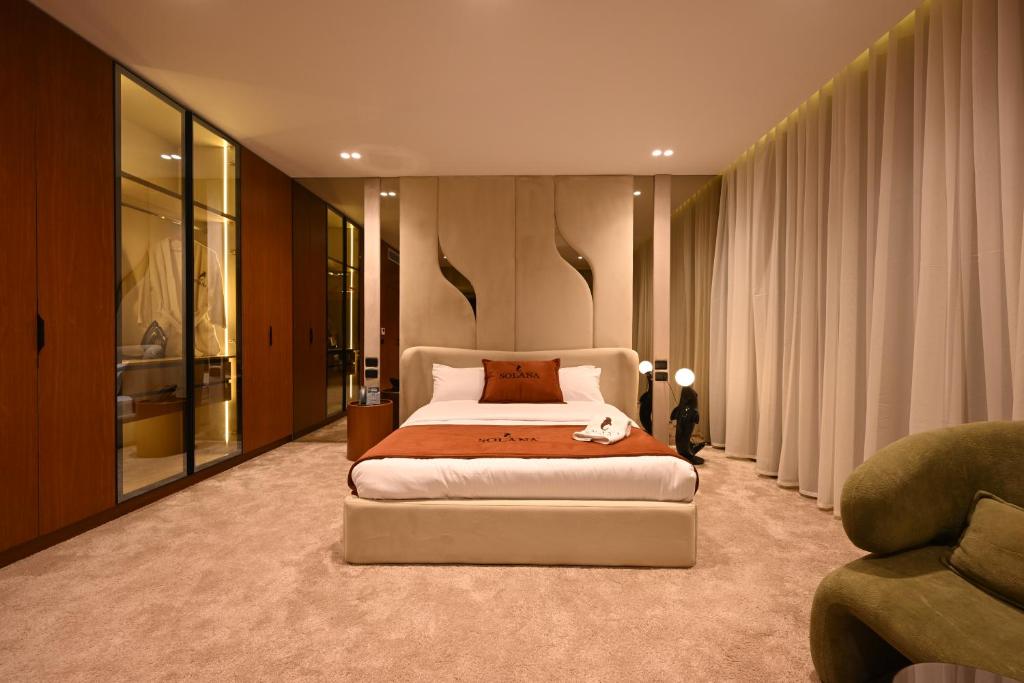 una camera da letto con un letto, un divano e una sedia di Solana Sky Pool Boutique Hotel a New cairo