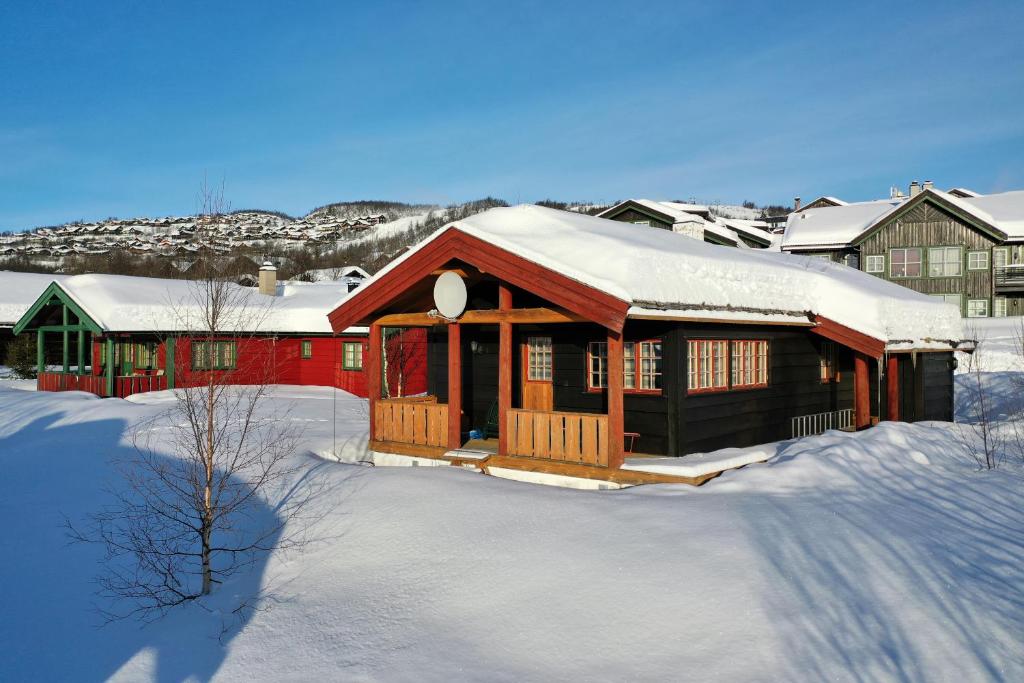 a cabin in the snow with snow covered roofs at Nostalgic Cabin With 3 Br, Fireplace, And Terrace in Beitostøl