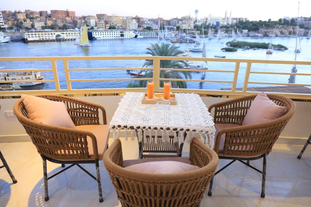 a table on a balcony with a view of a harbor at Crystala 2 guest house in Aswan