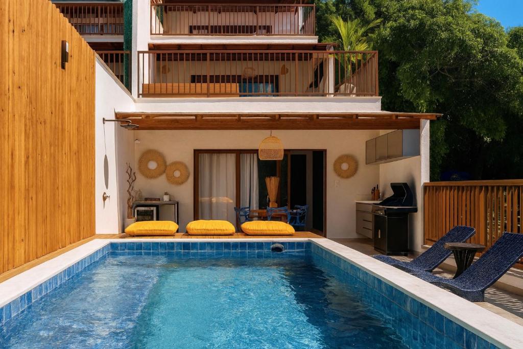 een zwembad met twee stoelen en een huis bij Casa Verano - Morro de São Paulo in Morro de São Paulo