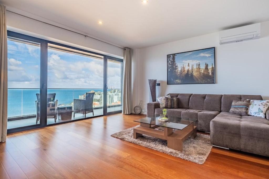una sala de estar con un sofá y una mesa en Ocean Vista- T2 Funchal, en Bicas