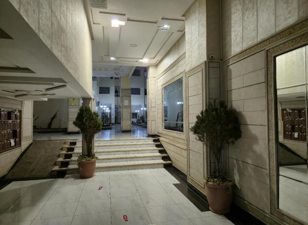 a hallway with potted plants and stairs in a building at Prime stay downtown Meknes in Meknès