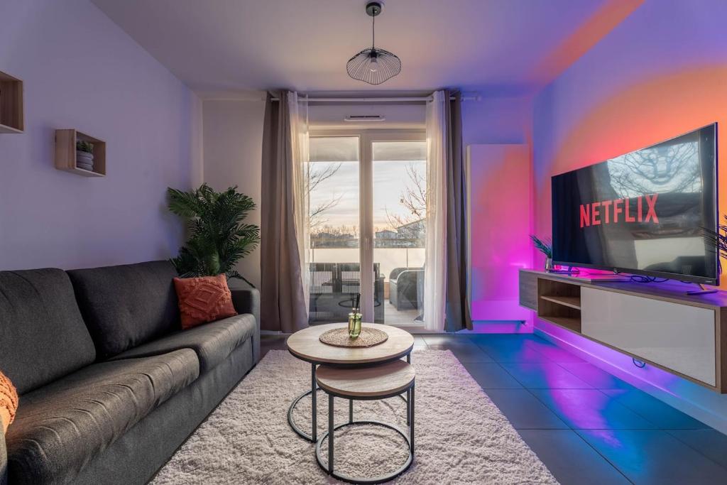 a living room with a couch and a tv at Le Magnifique - Grand balcon - Netflix - Grand Marché in Saint-Priest