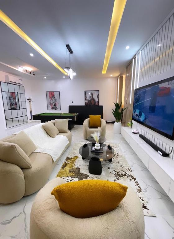 a large living room with a large tv and a couch at 2-Bedroom Apartment with Pool, Gym, Tennis & Snooker in Lekki Ajah in Lekki
