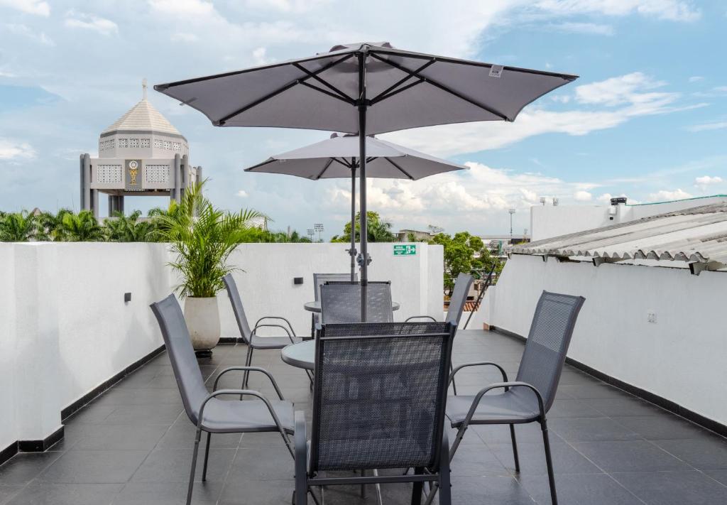 a patio with a table and chairs and an umbrella at Hotel Stadio Cali in Cali
