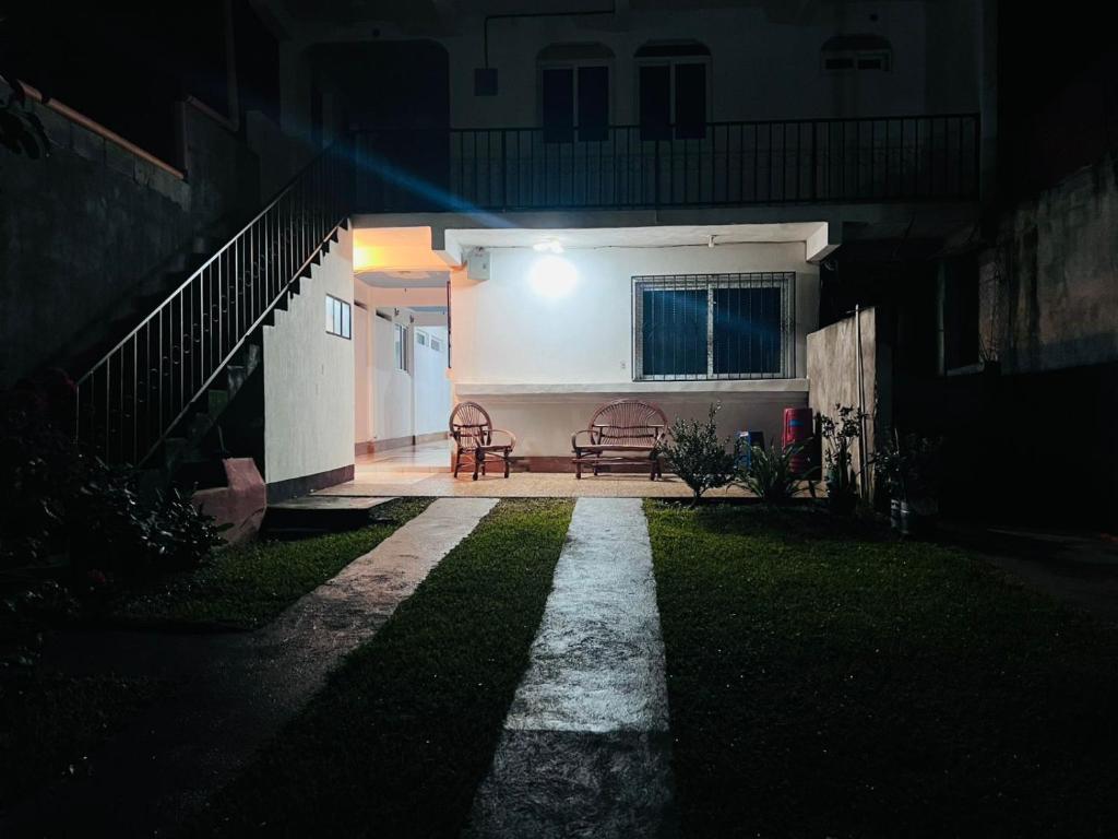 a house at night with two chairs and a staircase at Hotel Julián Cotuc in San Juan La Laguna